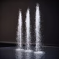 Three Garden Fountains With Spraying Water And Splashing Drops On Dark Background