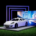 White Porsche Panamera Display Platform with Blue Neon Frame City Night View Screen Green Grass