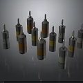 Multiple Cylindrical Weapon Components With Yellow Orange Gray Sections On Dark Surface