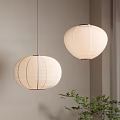 Round Striped Paper Pendant Lights Hanging in Room with Light Wall and Green Plant