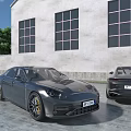 Two Gray Luxury Cars Parked Near Modern Building With Large Windows And Tree
