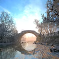 Stone Arch Bridge With Snow Covered Trees Frozen River Sunlight And Blue Sky