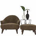 Beige Upholstered Leisure Chair With Ottoman Glass Side Table Vases Plant Blue Wall Wooden Floor