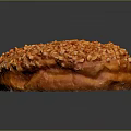 Golden Brown Round Pastry Topped with Crushed Nuts and Sweet Glaze