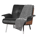 Modern Black Leather Armchair with Wooden Frame and Gray Knit Blanket on Metal Legs