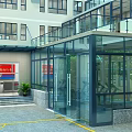 Gym Building with Glass Structure and Indoor Workout Equipment Surrounded by Green Trees