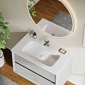 Elegant Bathroom Vanity Featuring Light Gray Cabinet Round Illuminated Mirror Decorative Painting and Green Plant