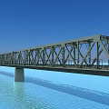 Steel Truss Bridge Spanning Water With Concrete Piers Against Blue Sky