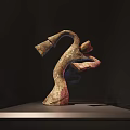 Abstract Sculpture With Curved Design On Display Stand In Dark Setting