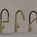 Three Modern Brushed Brass Faucets With Black Curved Spouts On Light Countertop