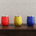 Vibrant Red Yellow Blue Tumblers With Silver Rim Placed On Wooden Table