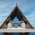 Triangular Wooden Roof Building With Large Glass Windows Steps White Decorations Blue Sky Water People Inside