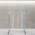 Sturdy Metal Rolling Clothes Rack With Hanging Garments Against Grey Wall