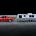 Red Pickup Truck Utility Vehicle Towing Silver Camper Trailer on Road
