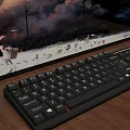Ergonomic Black Computer Keyboard On Desk With Animated Monitor Screen