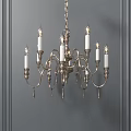 Classical Style Chandelier With Candle Shaped Lights And Metal Frame Against Gray Wall