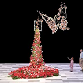 Butterfly Shaped Floral Installation With Tall Flower Arrangement And People Interacting On Checkerboard Floor