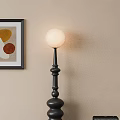 Black Floor Lamp With White Spherical Shade And Black Framed Colorful Circle Wall Art