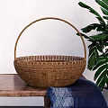 Woven Rattan Basket On Wooden Table With Green Plant And Blue Cloth
