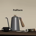 Poliform Decorative Ornament Set Including Silver Kettle Wooden Handle Glass Cup Open Magazine On Table