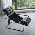 Modern Lounge Chair With Black Metal Frame And Gray Rounded Cushions By Window
