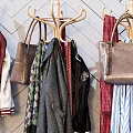 Stylish Clothes Hangers With Hanging Clothes Bags And Hats Against Geometric Patterned Wall