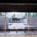 Residential Landscape View Through Glass Doors With Courtyard Water Feature Green Plants And Stone Pathway