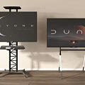 Two TVs Displaying BEYOND DUNE on Black Metal White Stands Against Light Wall Wooden Floor