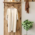Cream Robe With Lace Trim Hanging On Wooden Wall Near Brown Scarf And Green Plant
