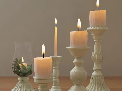 Lit White Candle Lamps with Various Designs on Wooden Tabletop and Glass Vase with Greenery 3d model
