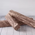 Rustic Stone Wood Logs Piled on Wooden Floor Against Light Colored Wall