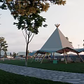 Luxury Glamping Campsite With Grassy Area Lounge Chairs String Lights And Wooden Platforms