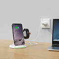 Smartphone On Wireless Charging Stand With Smartwatch Charging And Power Outlet Near Laptop