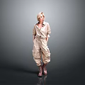 Blonde Woman in Beige Jumpsuit with Knee High Boots Standing Against Gray Background