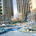 Snow Covered Residential Landscape With High Rise Buildings Trees Courtyard Greenery And Paved Area