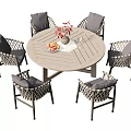 Outdoor Wicker Dining Set with Round Table Gray Cushioned Chairs Flower Vase and Fruit Platter