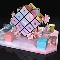 Colorful Brand Logo Cube Display With Pink Flowers And Decorative Elements