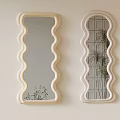 Two Wavy Framed Mirrors On Light Wall With Plant Reflections