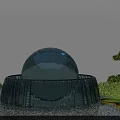 Garden Ornament Glass Sphere Fountain With Flowing Water Surrounded By Green Plants And Lily Pads
