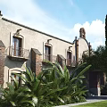 Spanish Style Detached Villa with Stone Brick Exterior Surrounded by Palm Trees and Greenery