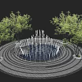 Circular Water Fountain With Multiple Water Jets And Surrounding Trees On Stone Pavement