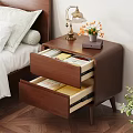 Wooden Nightstand With Open Drawers Containing Books And Table Lamp With Flower Pot