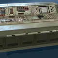 Industrial Control Console With Multiple Displays Control Panels Buttons And Green Beige Design