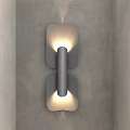 Modern Symmetrical Wall Light With Cylindrical Center Warm Lighting On Gray Concrete Wall