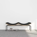 Black Wavy Seat Bench With Metal Legs Near Shoes And Books On Gray Carpet