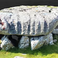 Outdoor Stone Structure With Large Top Slab And Supporting Stones On Green Grass