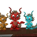 Three Carved Dragon Sculptures In Red Orange Blue With Golden Decorations On Wooden Table
