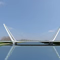 Modern Cable Stayed Landscape Bridge Spanning Calm Water With White Pylons And Blue Sky Reflection