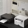 Black and White Printers by Window with Blinds and Printing Paper in Home Office Setup
