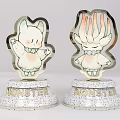 Two Different Monster Cartoon Figurines With Metallic Finish And MONSTER Bases